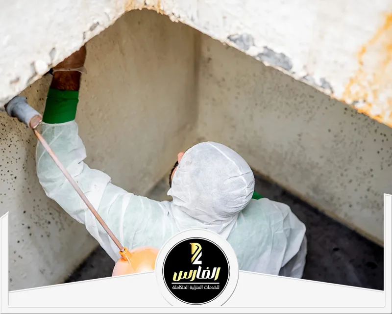 رجل يرتدي معطفًا أبيض يقوم بطلاء جدار.