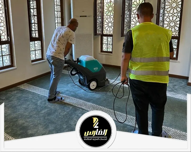 ثلاثة رجال ينظفون غرفة باستخدام مكانس كهربائية صفراء.