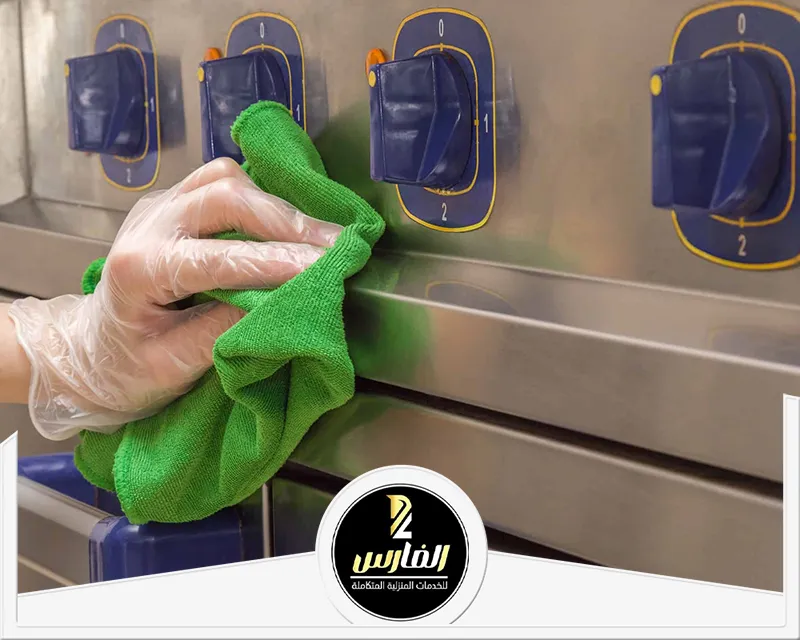 شركة تنظيف مطابخ بالرياض 0557756533 شركة الفارس نظيف واجهة الأجهزة المنزلية في المطبخ بالرياض باستخدام قماش نظيف ويد محمية بالقفاز.