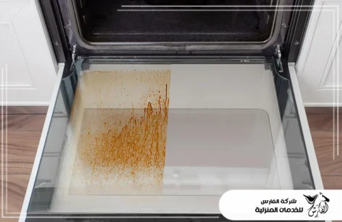 تلميع الافران بالرياض 0557756533 شركة الفارس صورة مقارنة تُظهر جزءًا من زجاج الفرن متسخًا بالدهون والجزء الآخر نظيفًا.