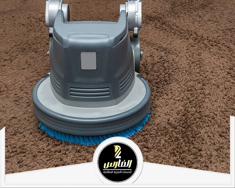 مكنسة كهربائية على أرضية مغطاة بالسجاد، تُستخدم لتنظيف الموكيت والسجاد.