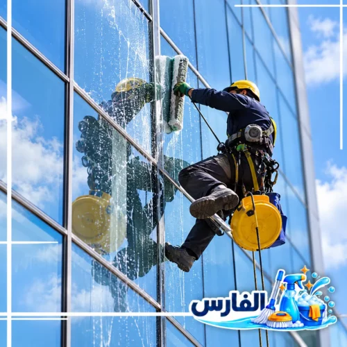 تنظيف الزجاج الخارجي للمباني بالرياض بتقنيات الوصول بالحبال تنظيف الواجهات الزجاجية المرتفعة باستخدام الحبال ومعدات السلامة وأدوات تنظيف متخصصة، مع ظهور شعار شركة الفارس.